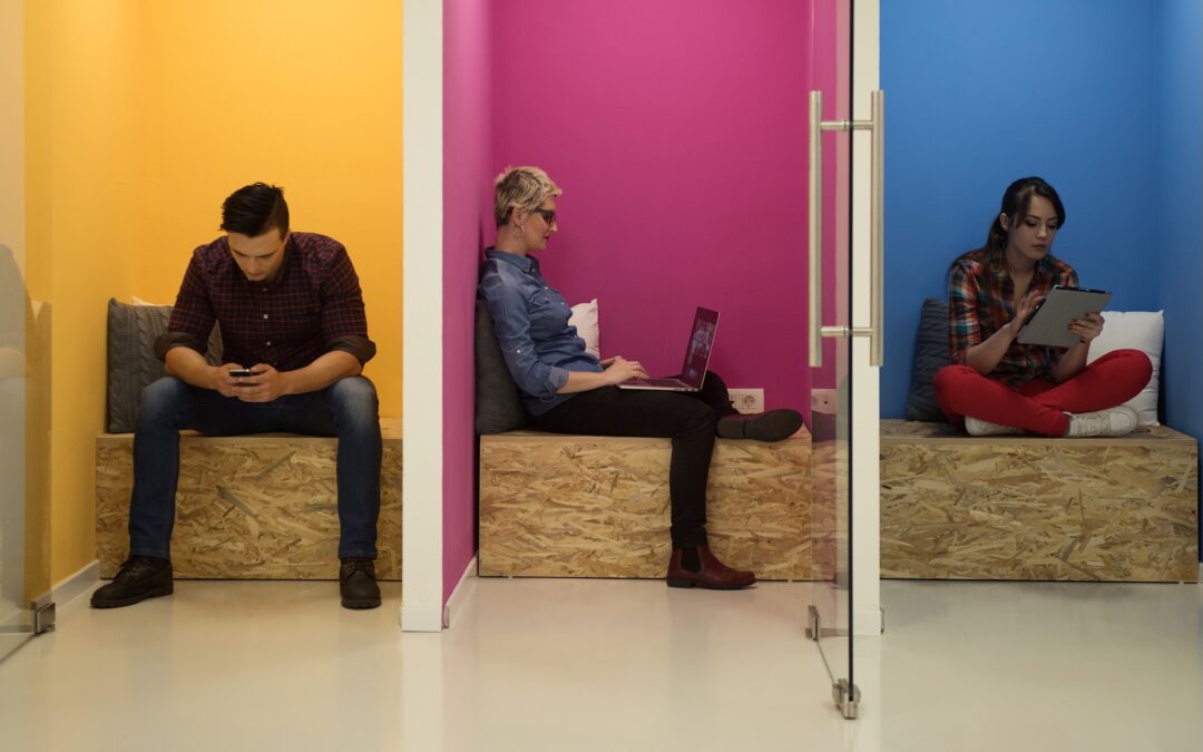 KI und Ethik. Menschen in Einzelkabinen an verschiedenen Devices am Arbeiten. Schattenseiten der Künstlichen Intelligenz