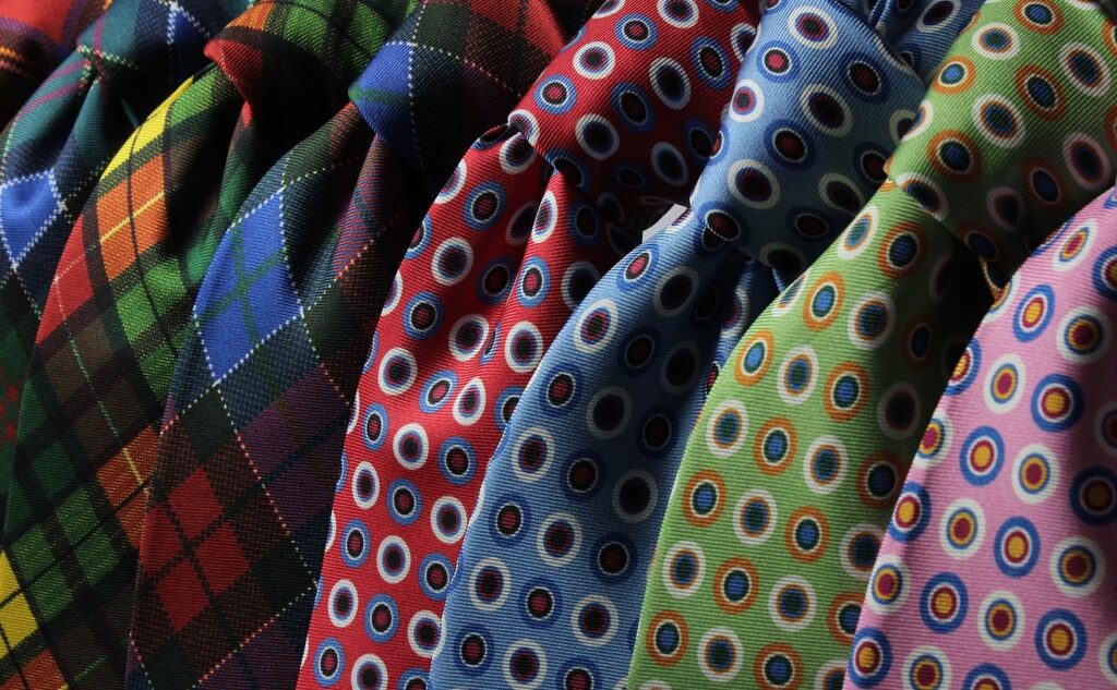 Verschieden farbige Kravatten, schön in einer Reihe drapiert. Auch eine schöne Kravatte kann die Selbstliebe vertiefen.